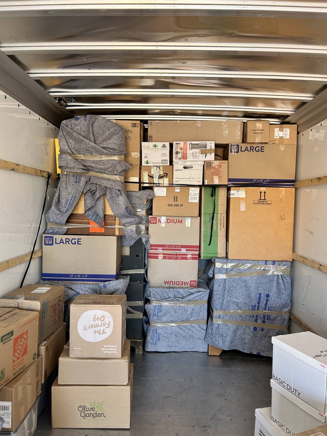 A moving truck packed with labelled cartons and wrapped furniture